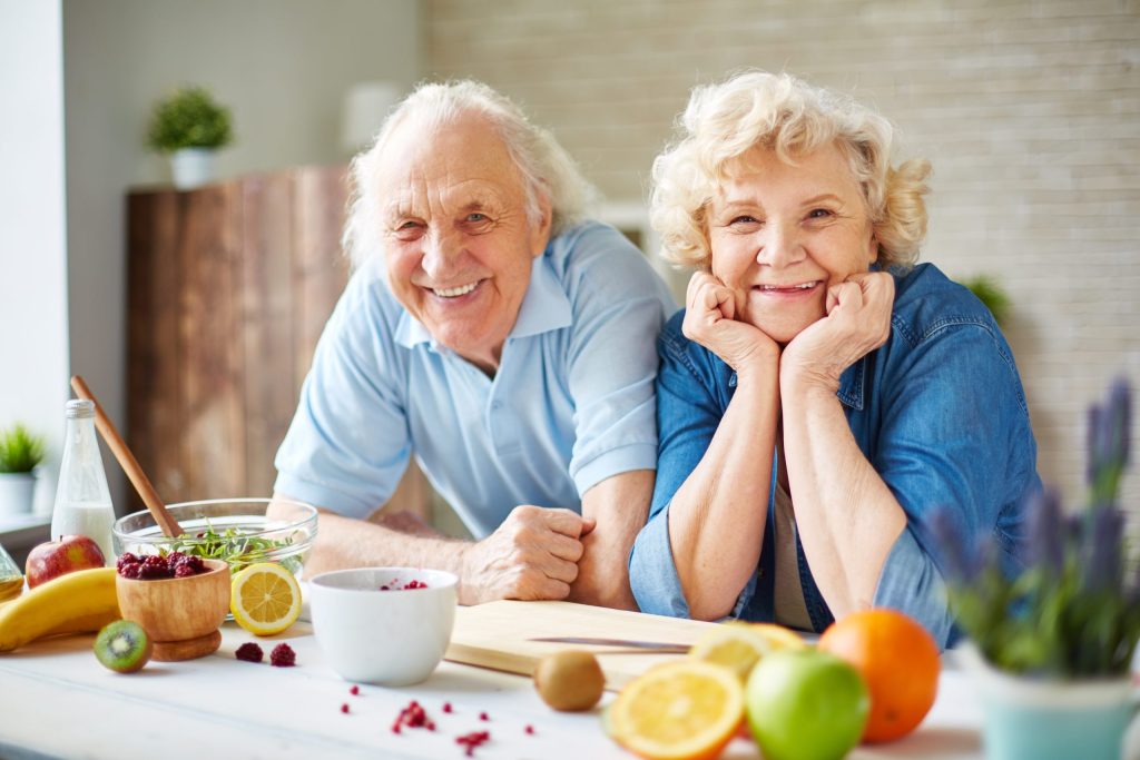 Seniors in kitchen with healthy fruits and vegetables