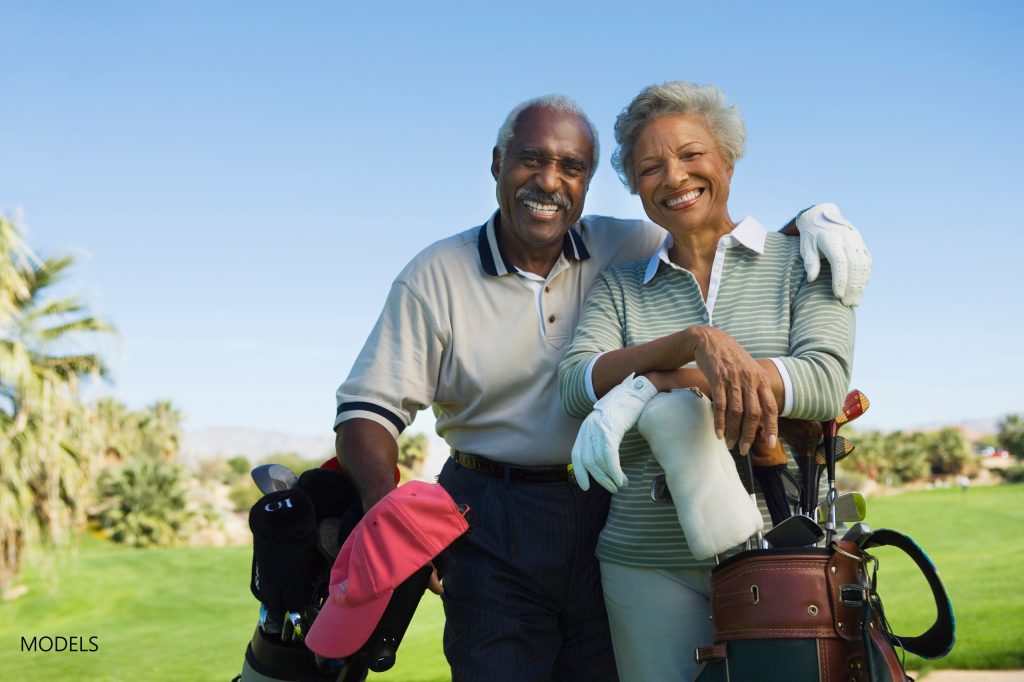 Smiling older couple on golf course