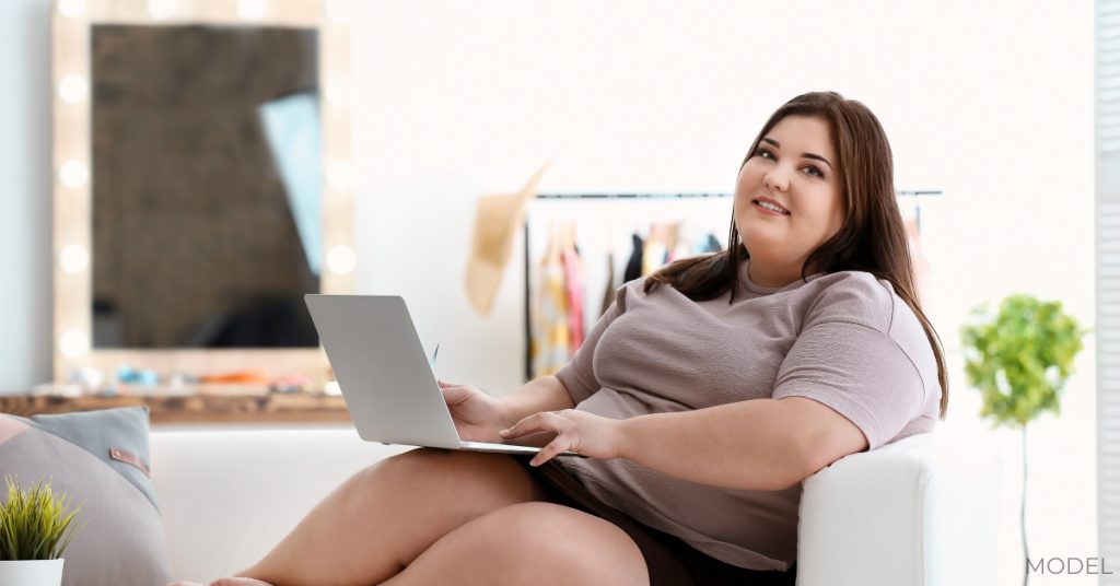 Overweight woman researching weight loss options (model)